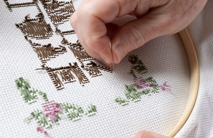 person holding white pink and green floral textile